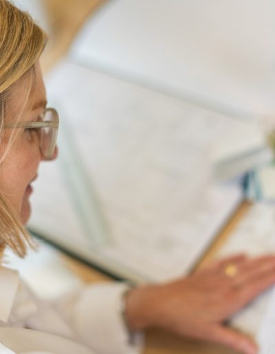 a woman works at her desk during a personal branding photography shoot in guildford