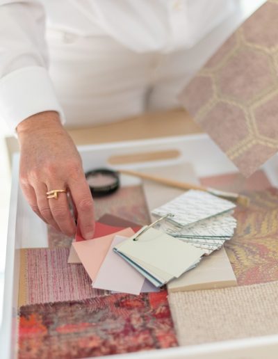a woman looks at samples in her interior design studio during a personal brand photography shoot in guildford