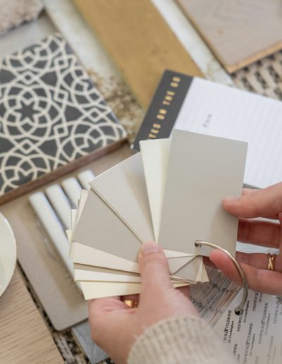 a woman looks at samples in her interior design studio during a personal brand photography shoot in guildford