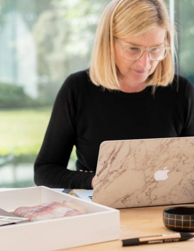 a woman works at her desk during a personal branding photography shoot in guildford