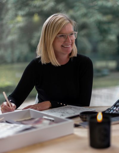 a woman works at her desk during a personal branding photography shoot in guildford