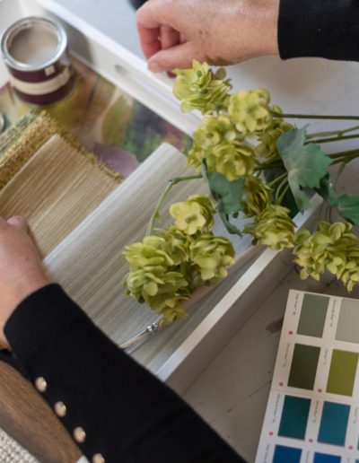 a woman looks at samples in her interior design studio during a personal brand photography shoot in guildford
