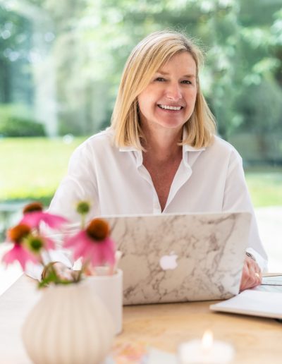 a woman works at her desk during a personal branding photography shoot in guildford