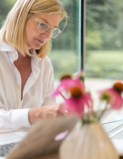 a woman works at her desk during a personal branding photography shoot in guildford