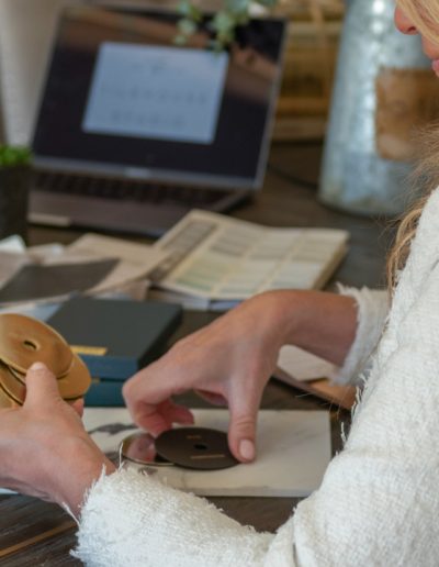 a woman looks at samples in her interior design studio during a personal brand photography shoot in guildford