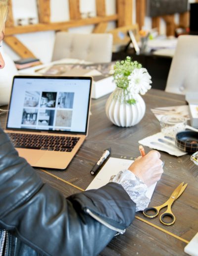 a young woman works at her desk during a personal branding photography shoot in guildford