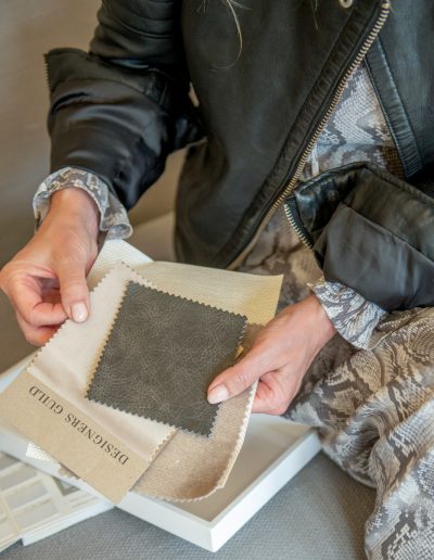a woman looks at samples in her interior design studio during a personal brand photography shoot in guildford