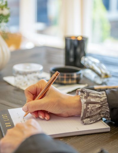 a young woman works at her desk during a personal branding photography shoot in guildford