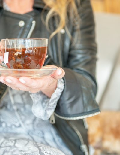 A woman holds a cup of tea during a personal branding photography shoot in guildford