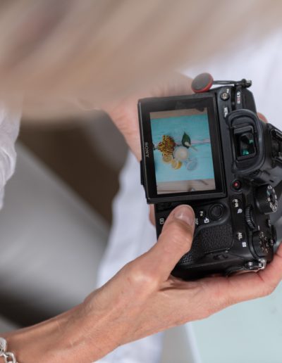 a woman checks images on the back of her camera during a personal branding photography shoot in surrey