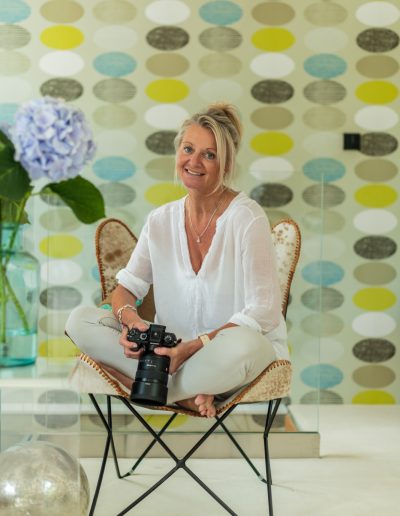 a woman sits cross legged on a chair during a personal branding photography shoot in guildford