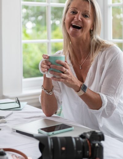 a woman laughs at the camera during a personal brand photography shoot in surrey