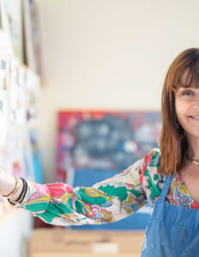 a woman in her art studio displaying her work during a personal brand photography shoot in guildford