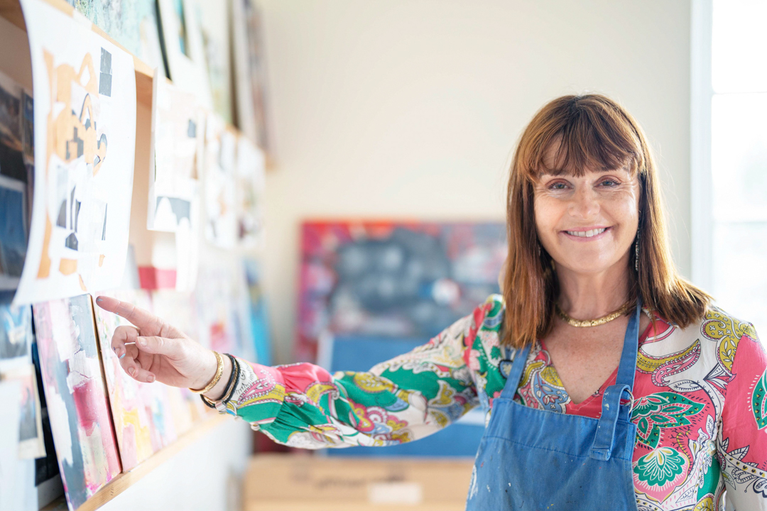 a woman in her art studio displaying her work during a personal brand photography shoot in guildford