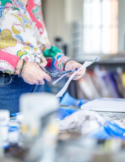 a woman in her art studio displaying her work during a personal brand photography shoot in guildford