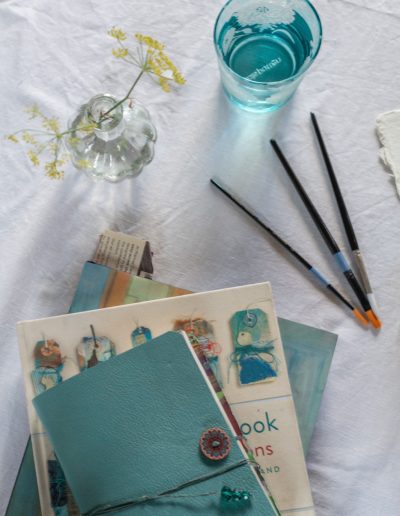 sketchbooks and paint brushes on a table during a lifestyle photography shoot in surrey