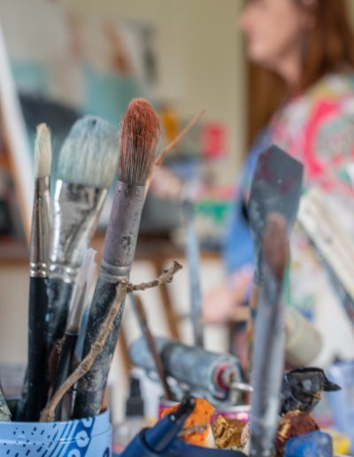 a collection of used paintbrushes in a jar during a personal brand photography shoot in guildford