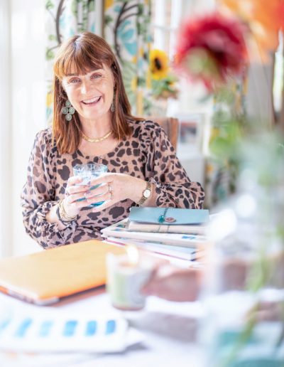 a young woman sits in a sun filled room during a personal brand photography shoot in guildford