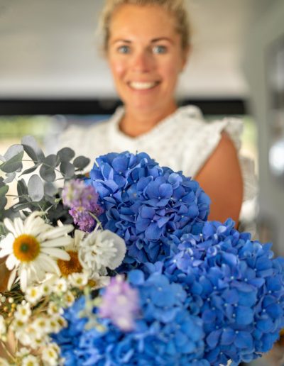 a young woman holds a large bunch of flowers during a personal brand photography shoot in guildford