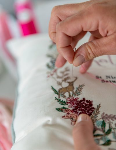 A woman embroiders a cushion during a personal branding photography shoot in surrey