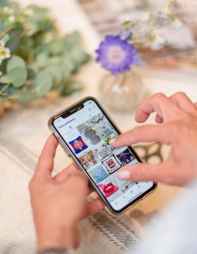 a woman checks her instagram feed during a personal branding photography shoot in surrey