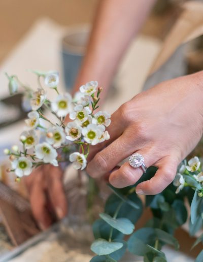 a woman arranges flowers during a personal branding photography shoot in surrey