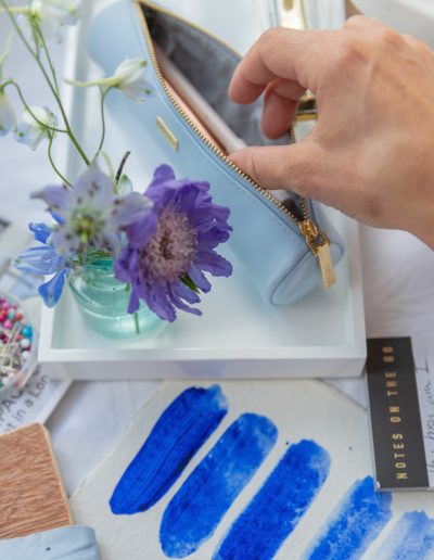 a woman picks out pencils from a pretty pencil case during a personal branding photography shoot in guildford