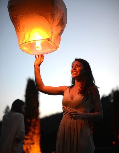 young woman sends a thai lantern into the evening sky during an event shot by surrey social stock photography