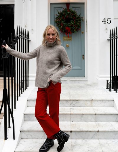a young woman stands outside a london townhouse at christmas during a personal brand photography shoot
