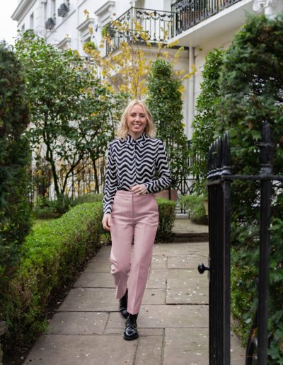 a young woman walks through a london park during a personal brand photography shoot in london