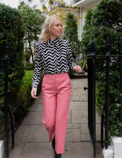 a young woman walks through a london park during a personal brand photography shoot in london