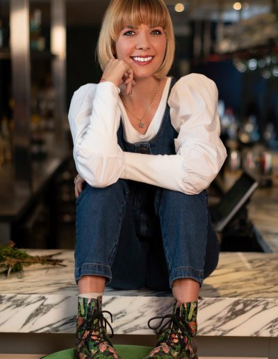 a young woman perches on a bar during a lifestyle photography shoot in guildford