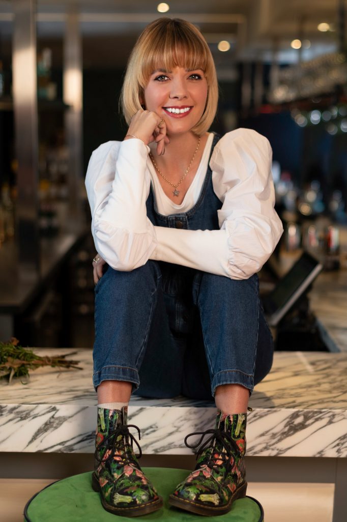 a young woman perches on a bar during a lifestyle photography shoot in guildford