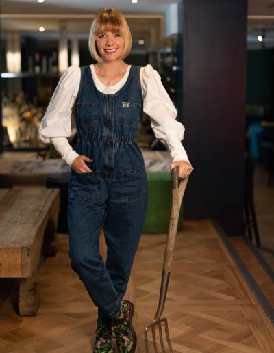 young woman poses with a garden fork for a lifestyle photography shoot in guildford