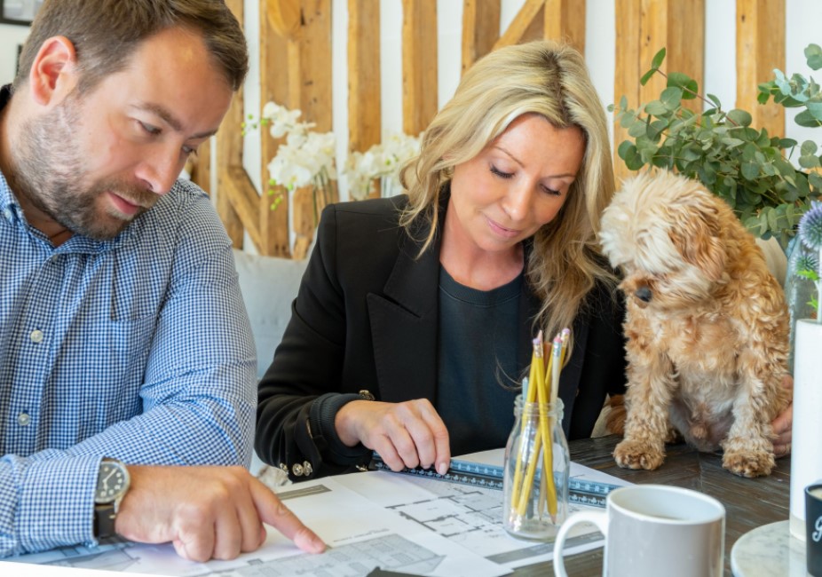 man and woman sitting at a work desk with a cute puppy during a personal branding photography shoot in guildford