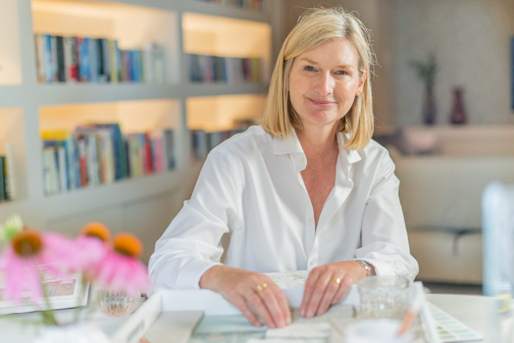 woman sits at her office desk with interior design samples