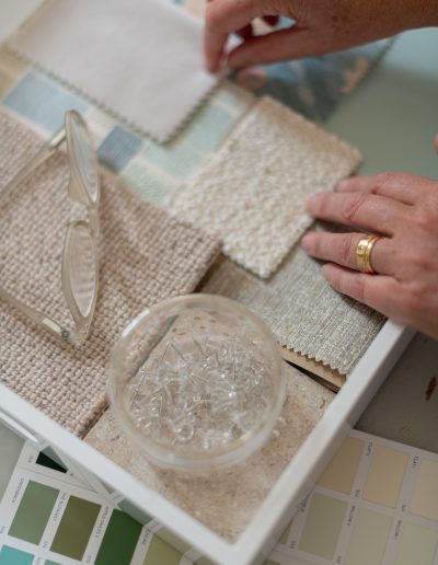 a woman looks at samples in her interior design studio during a personal brand photography shoot in guildford