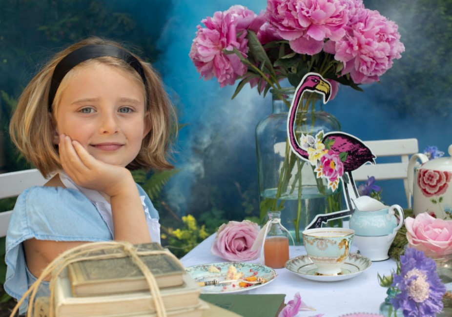 young girl dressed as Alice in Wonderland at a vintage mad hatter tea party photoshoot in surrey