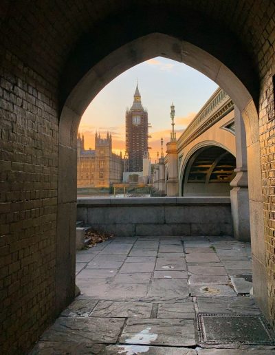 a view of the houses of parliament from an archway during a travel photography shoot in london
