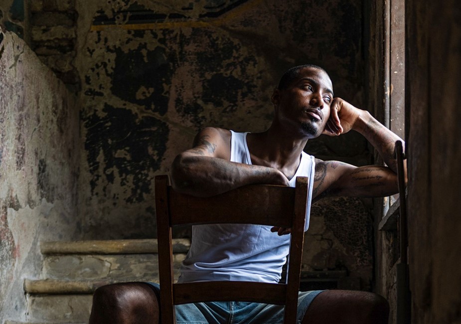 seated african american man looking broodily out of a window on personal brand photoshoot in surrey