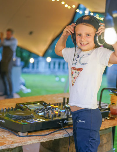 a young girl tries on DJ headphones at a summer event shot by surrey social stock photography