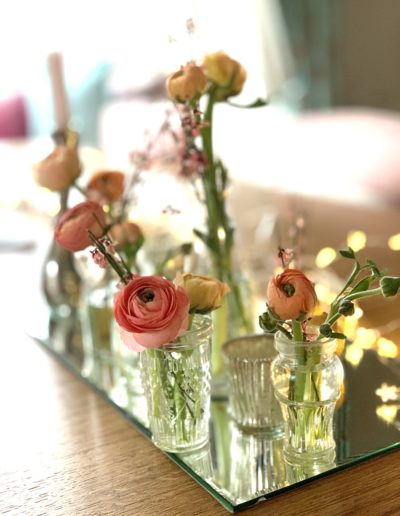 a set of vintage vases with flowers on a table setting