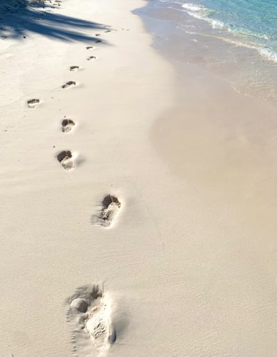 footsteps on the beach in nassau shot by travel photographers surrey social stock photography