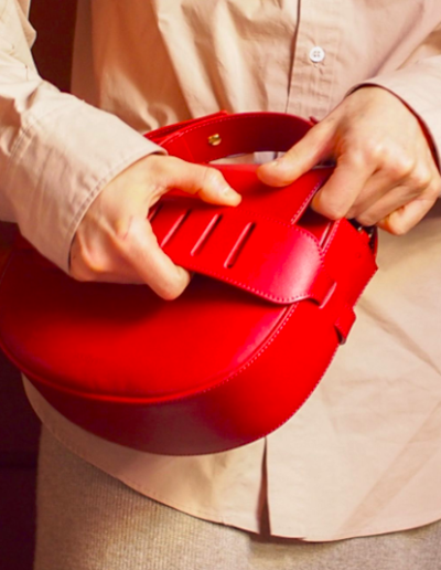 a woman opens a red bag