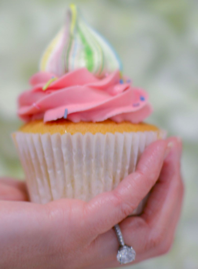 a woman holds a pink cupcake
