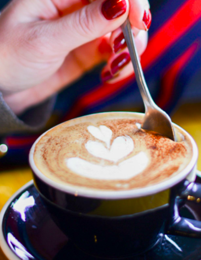 a woman stirs a cup of coffee