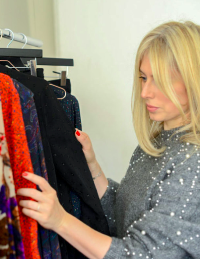 a fashion designer checks her products on a rack