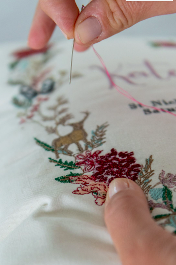 a textile designer sews a design