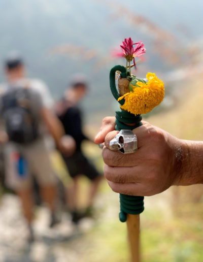 a hiking guide shows the way on the trail with his staff during a trek in nepal