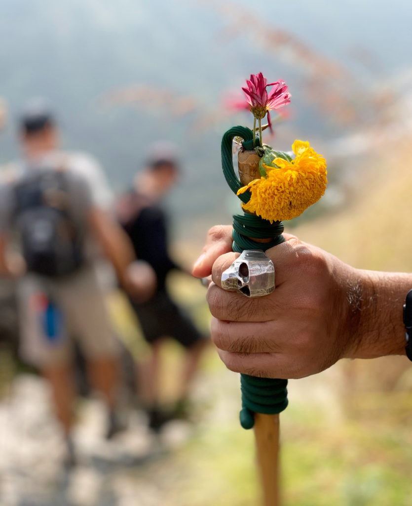 a hiking guide shows the way on the trail with his staff during a trek in nepal